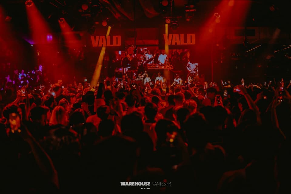 Concert de VALD au Warehouse Nantes : enseignes VALD au-dessus de la scène, wash rouge sur la salle